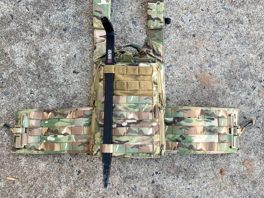 A knife and a vest are laying on the ground.